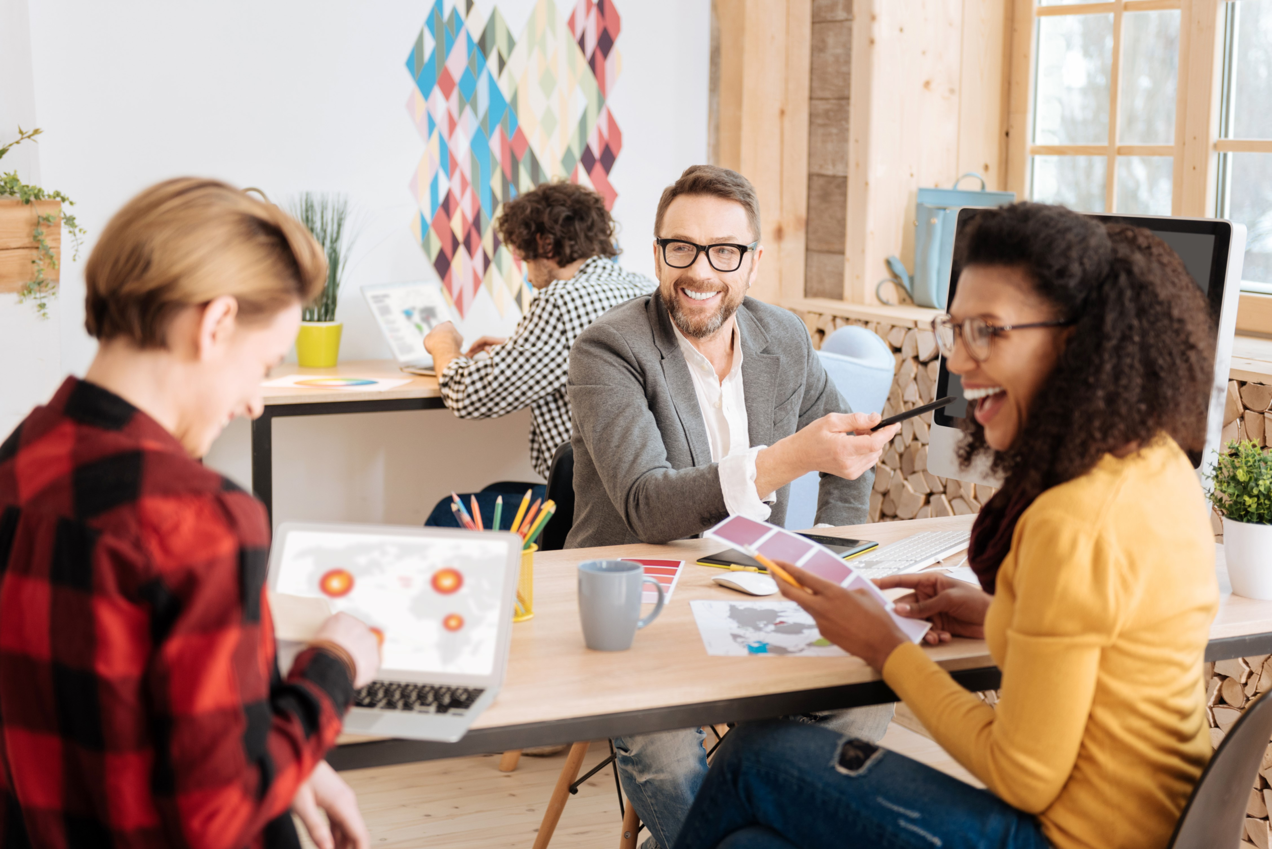 Une image de trois personnes assises sur un bureau et collaborant.